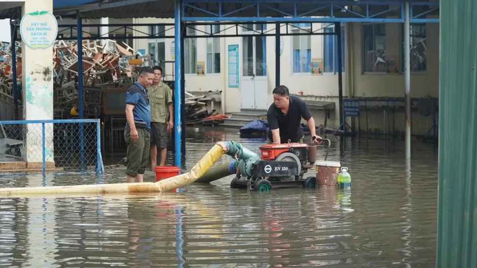 Phụ huynh phải cõng con vào lớp do sân trường ngập sâu Phụ huynh phải cõng con vào lớp do sân trường ngập sâu