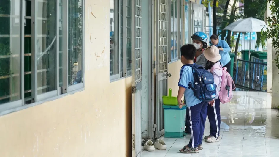 Phụ huynh phải cõng con vào lớp do sân trường ngập sâu Phụ huynh phải cõng con vào lớp do sân trường ngập sâu