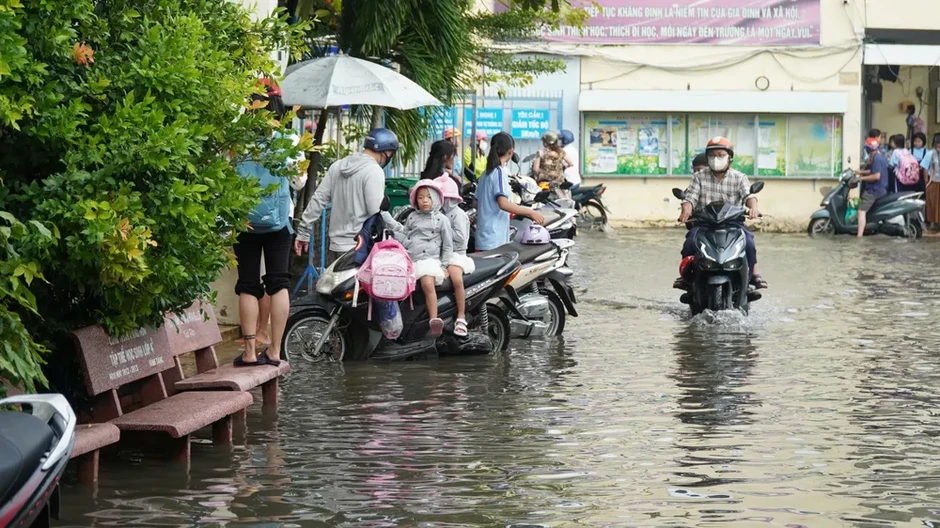 Phụ huynh phải cõng con vào lớp do sân trường ngập sâu Phụ huynh phải cõng con vào lớp do sân trường ngập sâu