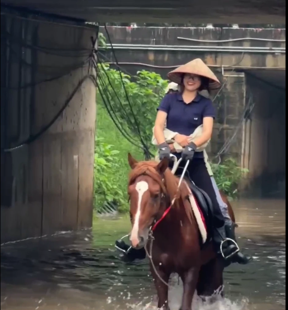 Cô gái cưỡi ngựa qua điểm ngập ở Hà Nội gây tranh luận