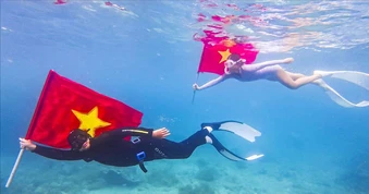 Bơi, lặn biển mang theo cờ Tổ quốc trên biển Quy Nhơn