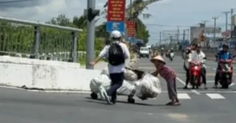 Hai nam sinh dừng xe giữa trời nắng nóng, giúp cụ bà gù lưng vượt dốc cầu