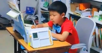 Mẹ cho con trai vừa học, vừa đạp máy may để rèn sự tập trung