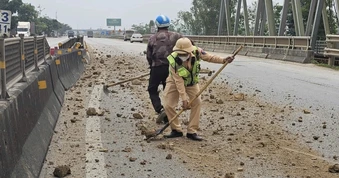 CSGT quét dọn đất đá rơi vãi trên quốc lộ