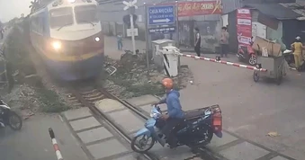 Lái xe máy thoát chết trong gang tấc khi cố tình lao qua đoàn tàu đang tới