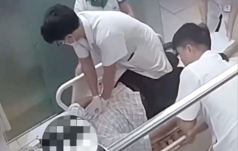 Bác sĩ trẻ ngồi trên băng ca, ép tim cứu bệnh nhân Bác sĩ trẻ ngồi trên băng ca, ép tim cứu bệnh nhân