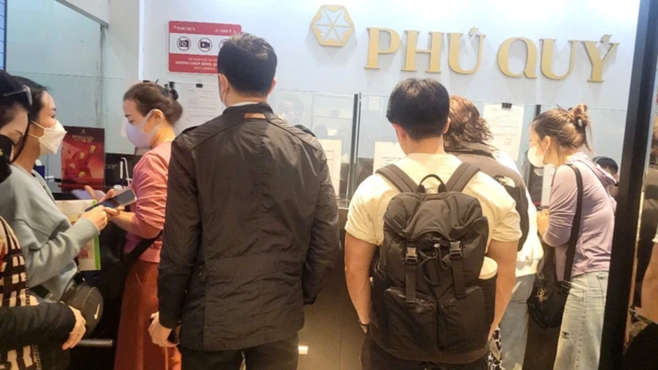 Người dân đội mưa xếp hàng chờ mua vàng trước ngày vía Thần Tài Người dân đội mưa xếp hàng chờ mua vàng trước ngày vía Thần Tài