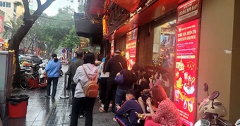Người dân đội mưa xếp hàng chờ mua vàng trước ngày vía Thần Tài