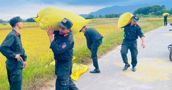 Cảnh sát cơ động giúp người đàn ông khuyết tật dọn lúa chạy mưa