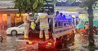 CSGT TPHCM dùng xe đặc chủng đưa người dân qua điểm ngập sâu