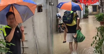 Hà Nội ngập nước khiến phụ huynh vất vả đưa con đến lớp giữa dòng nước mưa