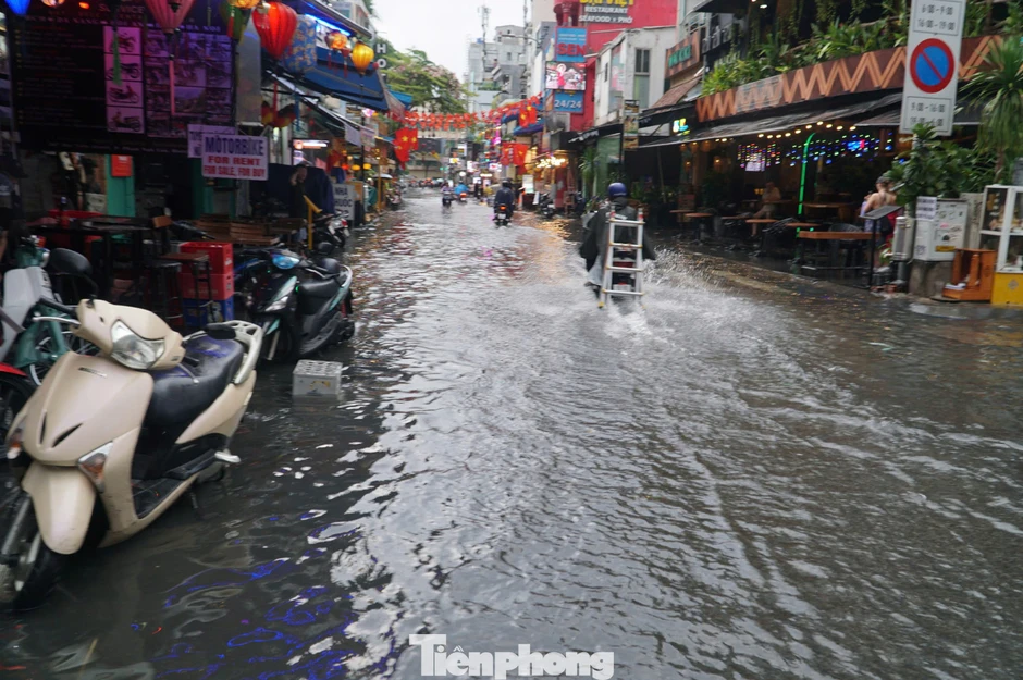 Người dân, du khách bì bõm lội nước trên 'phố Tây' Bùi Viện Người dân, du khách bì bõm lội nước trên 'phố Tây' Bùi Viện