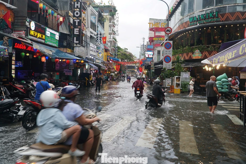 Người dân, du khách bì bõm lội nước trên 'phố Tây' Bùi Viện Người dân, du khách bì bõm lội nước trên 'phố Tây' Bùi Viện