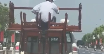 Người đàn ông ngồi trên xe bán tải biển xanh chở hàng thiếu an toàn tại Huế