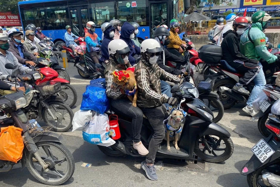 Trẻ nhỏ ngủ gục trên xe máy theo cha mẹ trở lại TPHCM sau kỳ nghỉ 30/4-1/5
