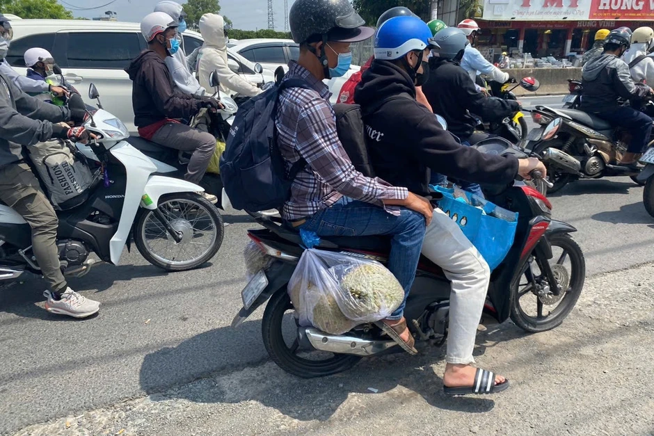 Trẻ nhỏ ngủ gục trên xe máy theo cha mẹ trở lại TPHCM sau kỳ nghỉ 30/4-1/5