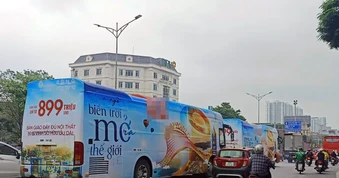2 xe ô tô khách cỡ lớn dán kín quảng cáo chạy trên đường phố Hà Nội