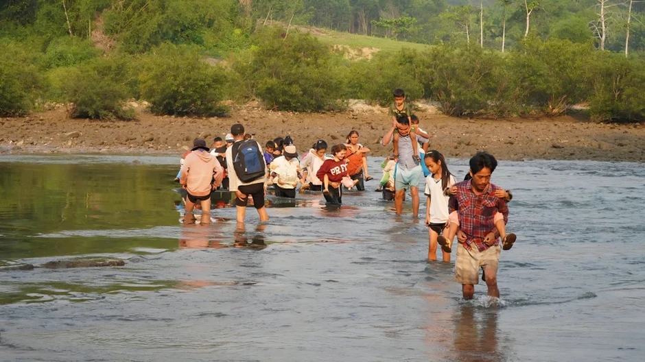 Bám lưng cha mẹ vượt sông đến trường