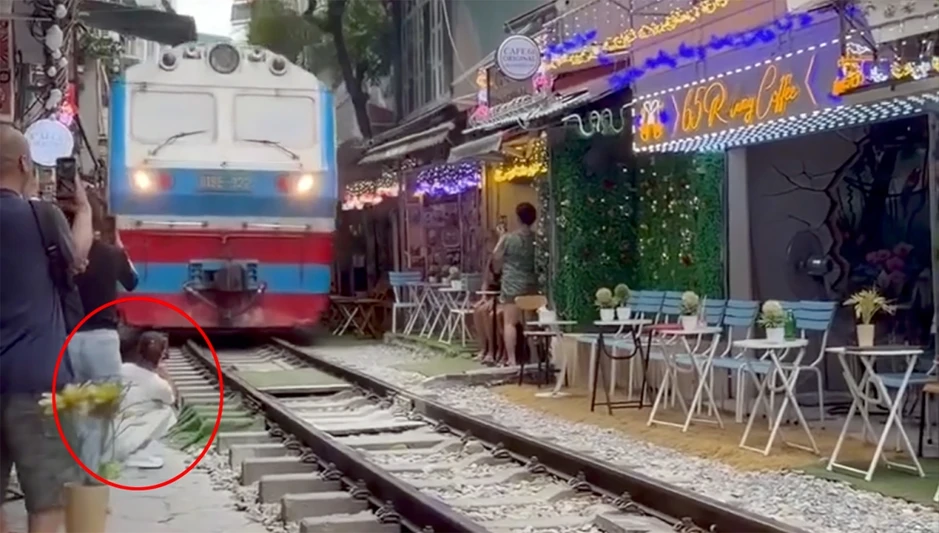 Cô gái ngồi cà phê đường tàu bị tàu hỏa hất văng điện thoại, suýt cuốn vào gầm Cô gái ngồi cà phê đường tàu bị tàu hỏa hất văng điện thoại, suýt cuốn vào gầm