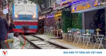 Cô gái ngồi cà phê đường tàu bị tàu hỏa hất văng điện thoại, suýt cuốn vào gầm