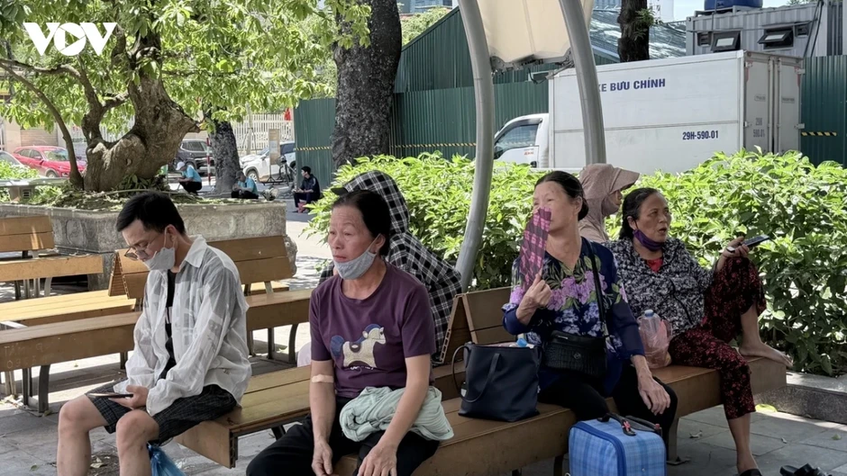 Người chăm bệnh nhân chật vật chống chọi với thời tiết nóng như đổ lửa ở Hà Nội