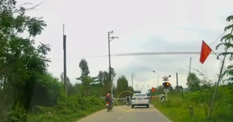 Thót tim cảnh 2 nữ sinh vượt rào chắn đường sắt trước đoàn tàu đang tới