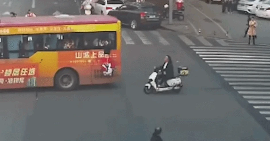 Bé gái treo lơ lửng ngoài cửa sổ xe buýt đang chạy, người đi xe máy lao tới cứu Bé gái treo lơ lửng ngoài cửa sổ xe buýt đang chạy, người đi xe máy lao tới cứu
