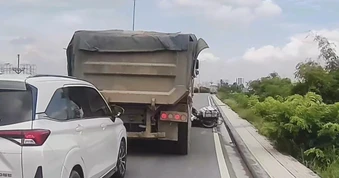 Chở hàng quá nặng, người đàn ông đi xe máy ngã ngay trước đầu xe tải