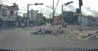 Lao qua ngã tư, cô gái đi xe máy đâm ngã người khác