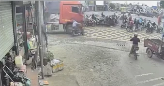 Người đi xe máy thoát chết trong gang tấc dưới bánh xe tải