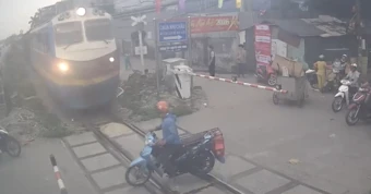 Vừa dùng điện thoại vừa 'cướp đường', xe máy bị tàu SE8 húc văng